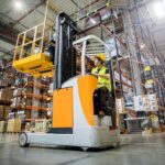 Forklift operator during work in large warehouse