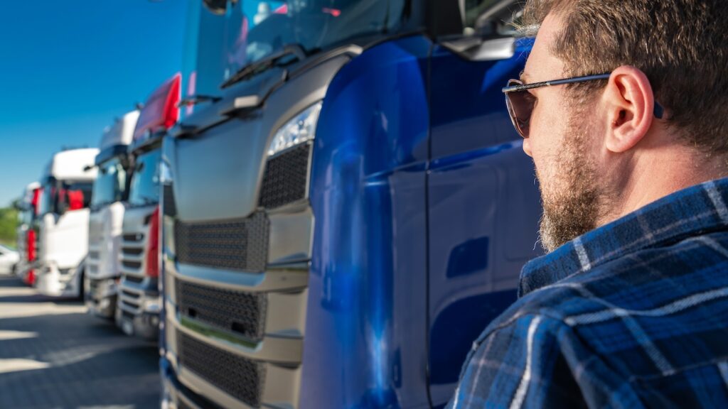 Caucasian Transportation Industry Business Owner Staying Next to His Truck Fleet